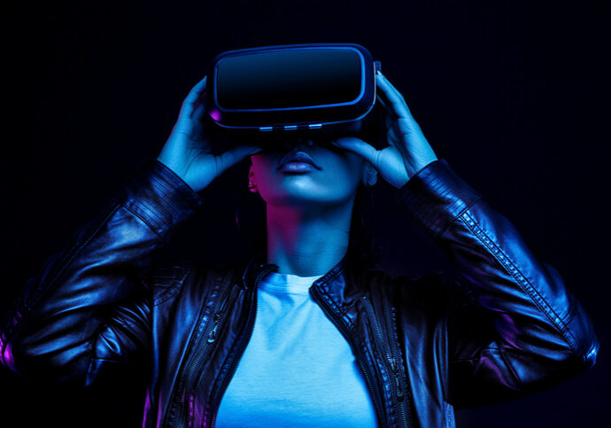 African american girl in vr glasses, watching 360 degree video with virtual reality headset isolated on black background, illuminated by neon lights